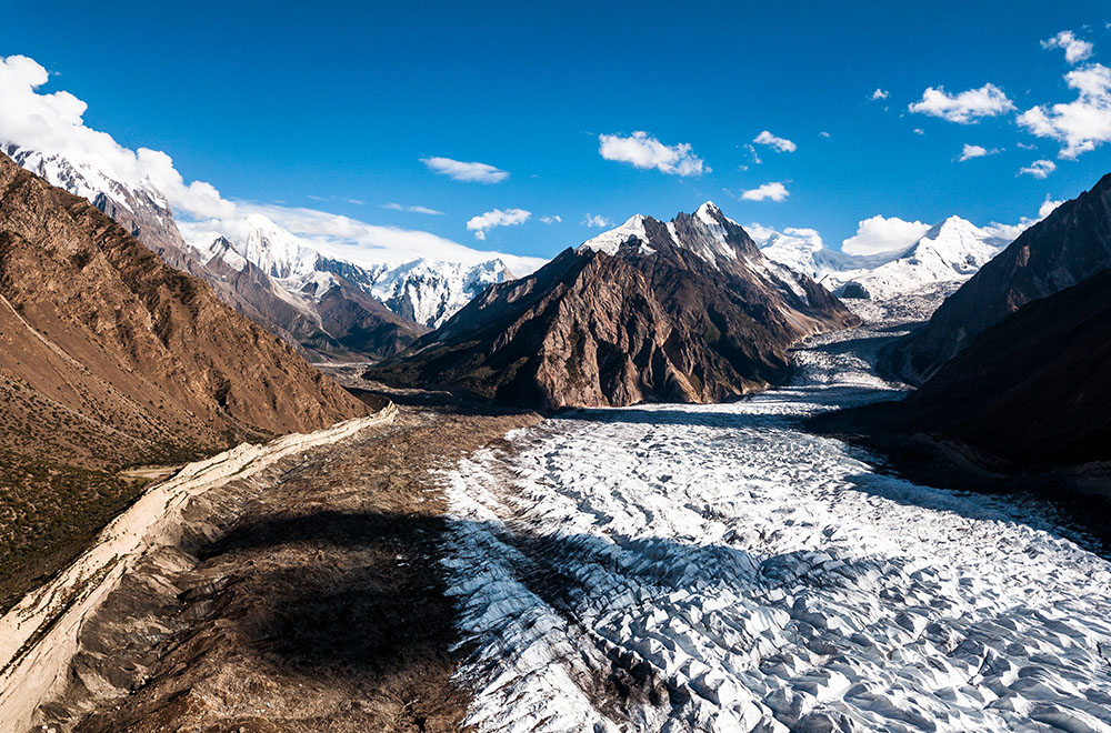 An aerial photograph of two glaciers converging in the in Hoper Valley region of Nagar, Gilgit-Baltistan, Pakistan.